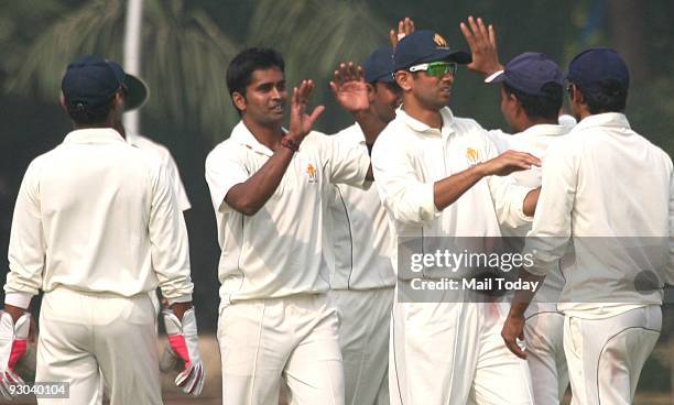 Captain of the Karnataka Ranji team Rahul Dravid celebrates a dismissal with his team at a Group B match of the Ranji Trophy Super League on Tuesday,...