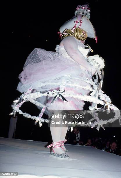 Americn actor Harris Glenn Milstead , better known as Divine, walks the catwalk in a white and pink hoop wedding dress during a fashion show, New...