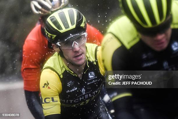 Great Britain's Simon Yates , wearing the overall leader's yellow jersey, rides during heavy rainfall during the 110 km eighth and last stage of the...