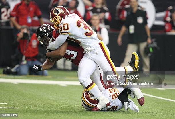 Michael Turner of the Atlanta Falcons is tackled by LaRon Landry and DeAngelo Hall of the Washington Redskins at the Georgia Dome on November 8, 2009...