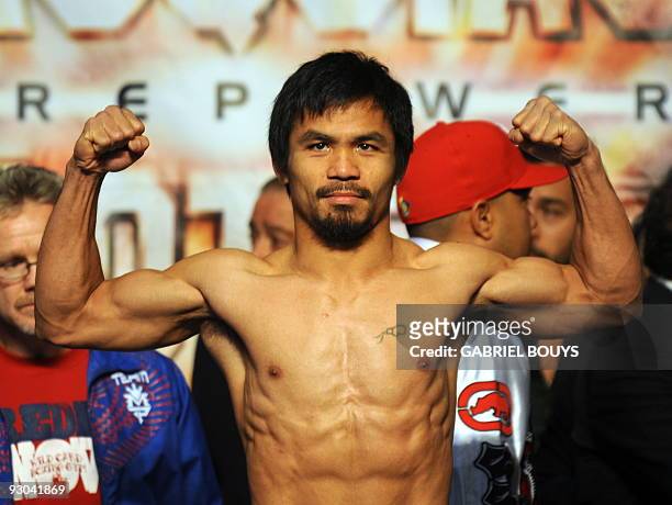 Welterweight boxing champion Manny "PacMan" Pacquiao of the Philippines poses during the official weigh-in for his fight against WBO champion Miguel...