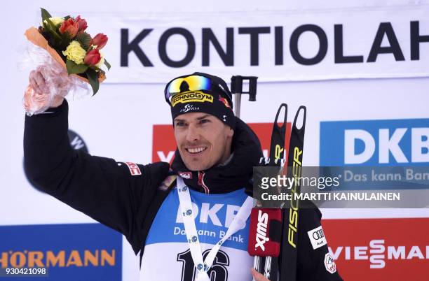 Winner Julian Eberhard of Austria poses on the podium after the men's 15km mass start event at the IBU Biathlon World Cup in Kontiolahti, Finland, on...