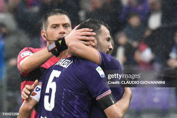 Fiorentina's midfielder and new captain Milan Badelj reacts as referee Fabrizio Pasqua and Fiorentina's defender Vincent Laurini comfort him, on...