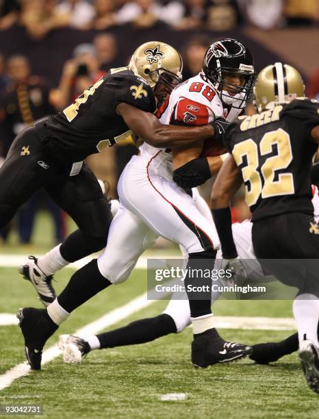 Tony Gonzalez of the Atlanta Falcons runs with a catch against Jonathan Vilma and Jabari Greer the New Orleans Saints at the Louisiana Superdome on...