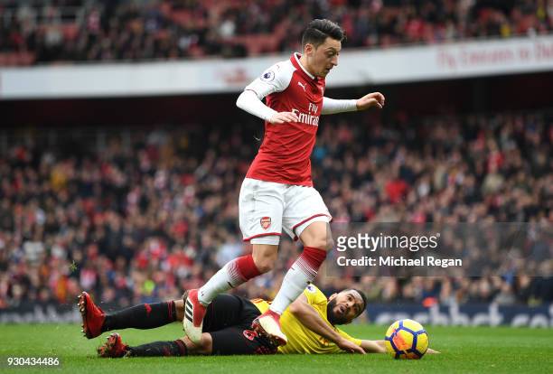 Mesut Ozil of Arsenal goes past Adrian Mariappa of Watford during the Premier League match between Arsenal and Watford at Emirates Stadium on March...