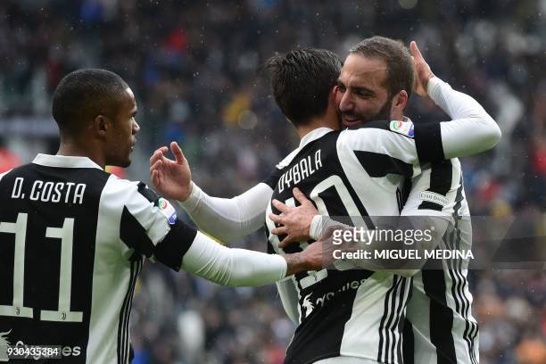 Juventus' forward from Argentina Paulo Dybala celebrates with teammates Juventus' forward from Brazil Douglas Costa and Juventus' forward from...