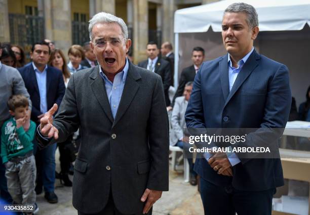 Colombian former president and current senator Alvaro Uribe speaks to the press next to presidential candidate Ivan Duque, who is planning to run for...