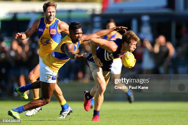 Lee Spurr of the Dockers looks to break from a tackle by Liam Ryan of the Eagles during the JLT Community Series AFL match between the Fremantle...