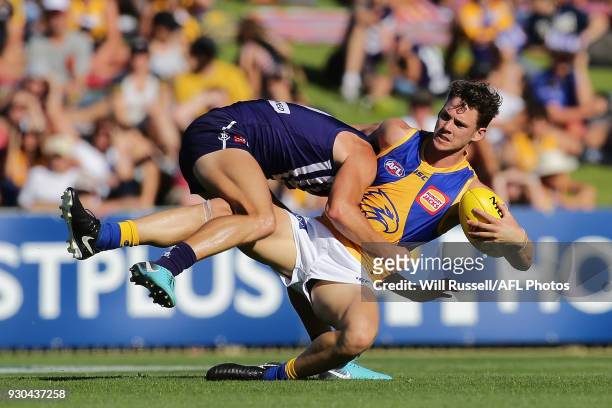 Jack Redden of the Eagles is tackled by Darcy Tucker of the Dockers during the JLT Community Series AFL match between the Fremantle Dockers and the...