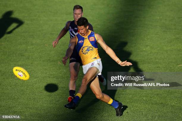 Liam Duggan of the Eagles kicks the ball under pressure from Brandon Matera of the Dockers during the JLT Community Series AFL match between the...