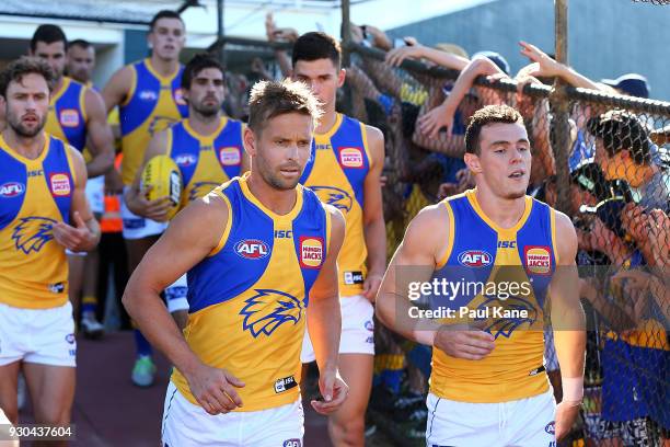 Mark LeCras and Luke Shuey of the Eagles run down the race onto the field during the JLT Community Series AFL match between the Fremantle Dockers and...