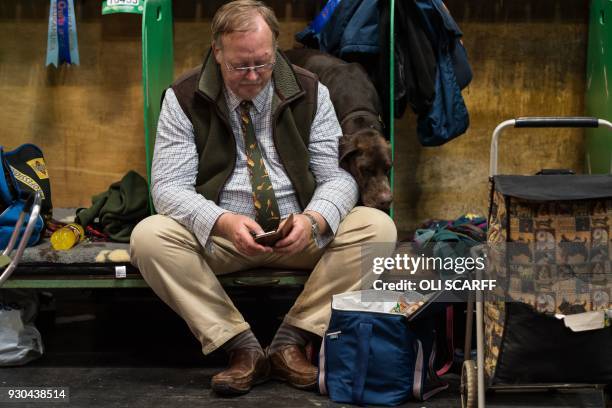 Man sits in a pen with his German Shorthaired Pointer on the final day of the Crufts dog show at the National Exhibition Centre in Birmingham,...