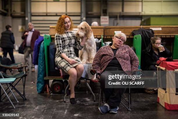 Woman sits with her Italian Spinone dog on the final day of the Crufts dog show at the National Exhibition Centre in Birmingham, central England, on...