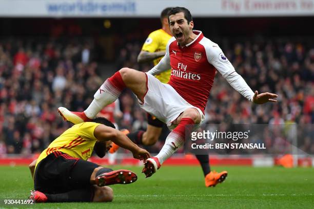 Arsenal's Armenian midfielder Henrikh Mkhitaryan reacts to a challenge from Watford's English-born Jamaican defender Adrian Mariappa during the...