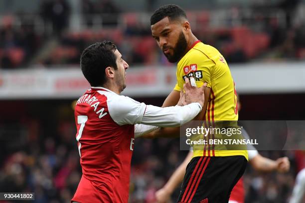 Arsenal's Armenian midfielder Henrikh Mkhitaryan clashes with Watford's English-born Jamaican defender Adrian Mariappa during the English Premier...