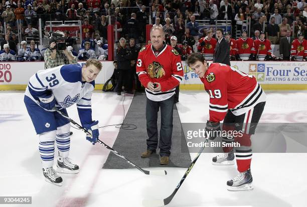 Ryne Sandberg, former second baseman for the Chicago Cubs drops the puck with Jonathan Toews of the Chicago Blackhawks and John Mitchell of the...