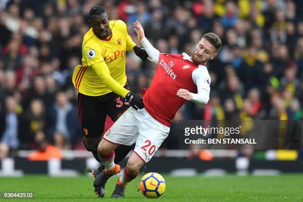Watford's Italian striker Stefano Okaka vies with Arsenal's German defender Shkodran Mustafi during the English Premier League football match between...