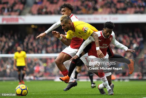 Roberto Pereyra of Watford is fouled by Ainsley Maitland-Niles of Arsenal and Alex Iwobi of Arsenal for a penalty during the Premier League match...