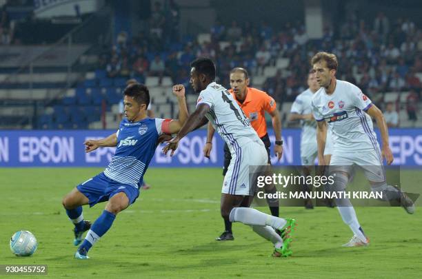 Pune players Rohit Kumar and Rafael Gomez Lopez look on as Bengaluru FC captain Sunil Chhetri kicks the ball during the Hero Indian Super League...