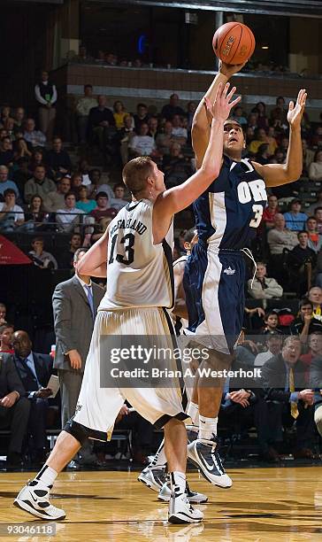 Damen Bell-Holter of the Oral Roberts Golden Eagles shoots over Chas McFarland of the Wake Forest Demon Deacons on November 13, 2009 in...