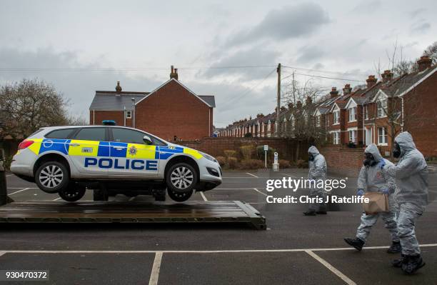 Military personnel wearing protective suits remove a police car and other vehicles from a public park as they continue investigations into the...