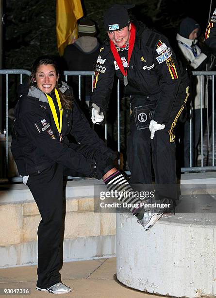 It was a cold night on the podium as pilot Sandra Kiriasis of Germany, second place, gives a thumbs up to the socks of Bree Schaaf of the USA, fourth...