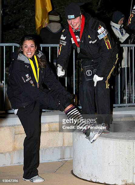 It was a cold night on the podium as pilot Sandra Kiriasis of Germany, second place, gives a thumbs up to the socks of Bree Schaaf of the USA, fourth...