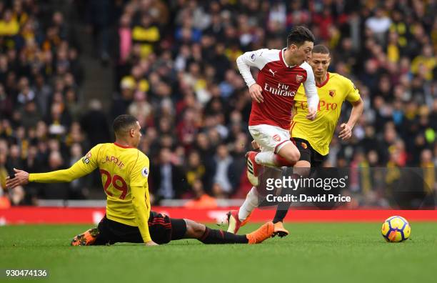 Mesut Ozil of Arsenal takes on Etienne Capoue of Watford during the Premier League match between Arsenal and Watford at Emirates Stadium on March 11,...
