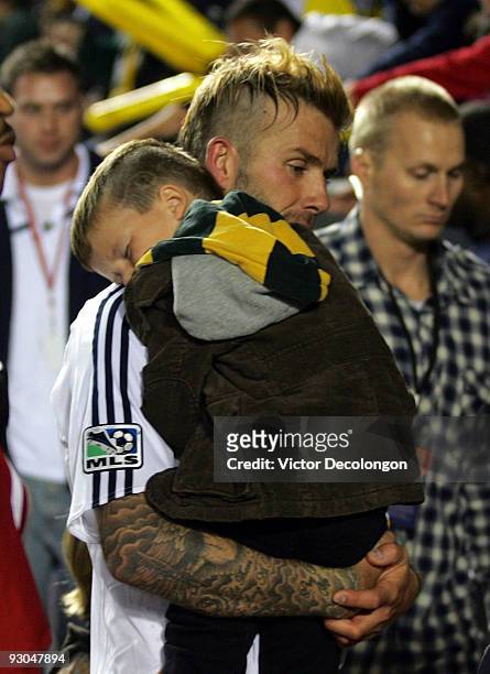 David Beckham of the Los Angeles Galaxy carries his son Cruz in his arms into the locker room after the Galaxy defeated the Houston Dynamo 2-0 in the...