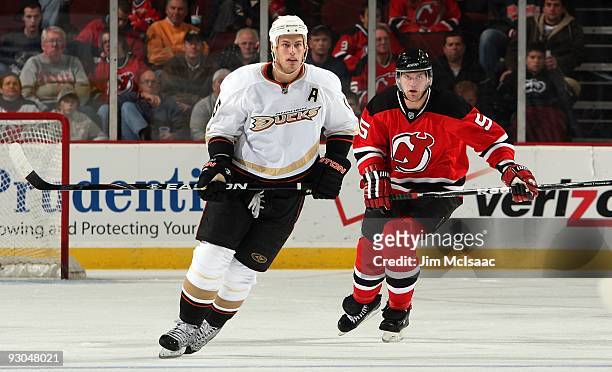 Ryan Getzlaf of the Anaheim Ducks skates against Colin White of the New Jersey Devils during their NHL game at the Prudential Center on November 11,...