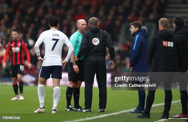 Referee Mike Dean speaks to the fourth offical Graham Scott during the Premier League match between AFC Bournemouth and Tottenham Hotspur at Vitality...