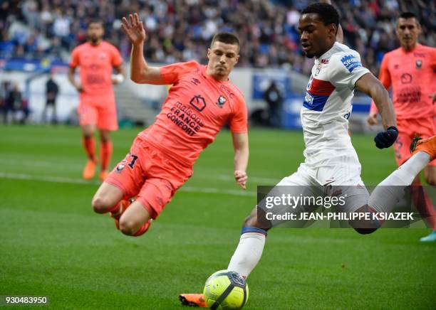 Caen's French defender Frederic Guilbert vies with Lyon's French forward Myziane Maolida during the French L1 football match Lyon vs Caen , on March...