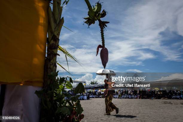 Hindu devotee carries his daughter during the Melasti ritual ceremony at Parangkusumo beach on March 11, 2018 in Yogyakarta, Indonesia.The Melasti...