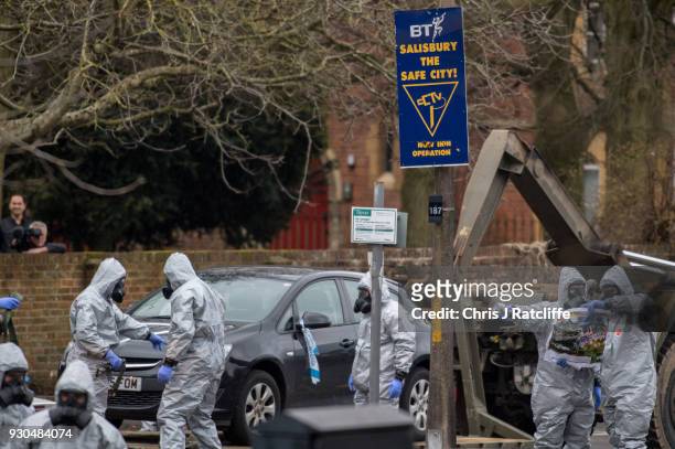 Military personnel wearing protective suits remove a police car and other vehicles from a public car park as they continue investigations into the...