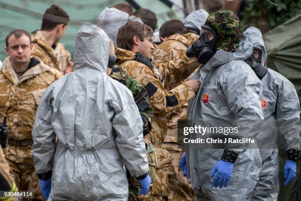 Military personnel wearing protective suits remove a police car and other vehicles from a public car park as they continue investigations into the...