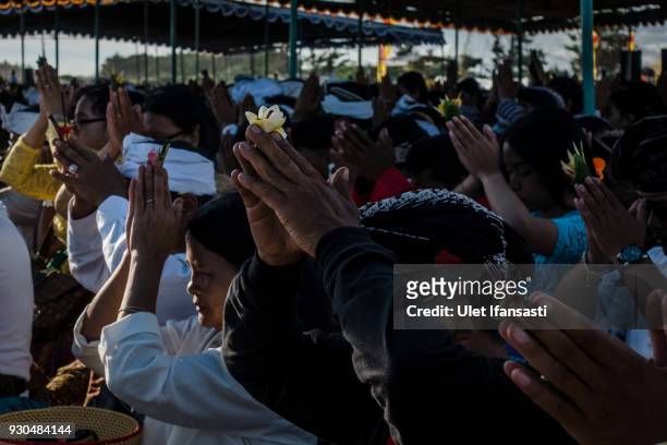 Hindus devotees pray during the Melasti ritual ceremony at Parangkusumo beach on March 11, 2018 in Yogyakarta, Indonesia.The Melasti ritual is held...