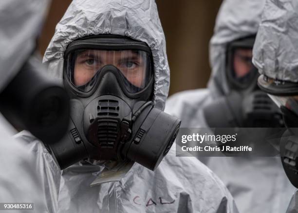 Military personnel wearing protective suits remove a police car and other vehicles from a public car park as they continue investigations into the...