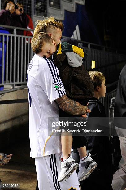 David Beckham of the Los Angeles Galaxy carries his son Cruz in his arms into the locker room after the Galaxy defeated the Houston Dynamo 2-0 in the...