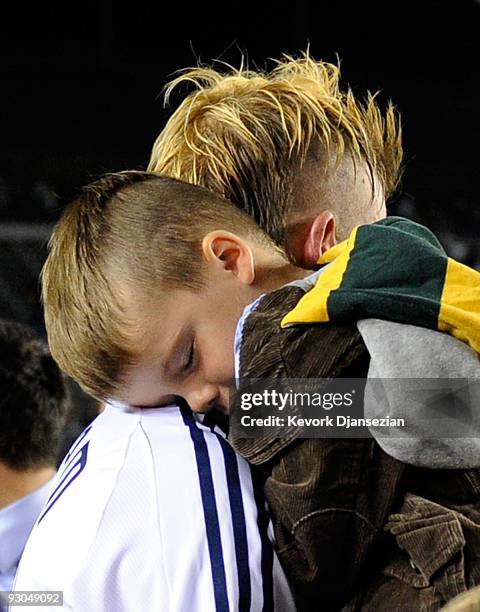 David Beckham of the Los Angeles Galaxy carries his son Cruz in his arms into the locker room after the Galaxy defeated the Houston Dynamo 2-0 in the...
