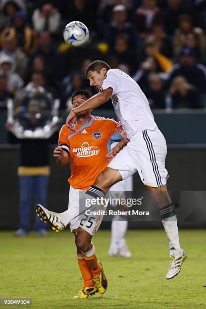 Omar Gonzalez of the Los Angeles Galaxy heads a ball over Brian Ching of the Houston Dynamo during their MLS Western Conference Championship game at...