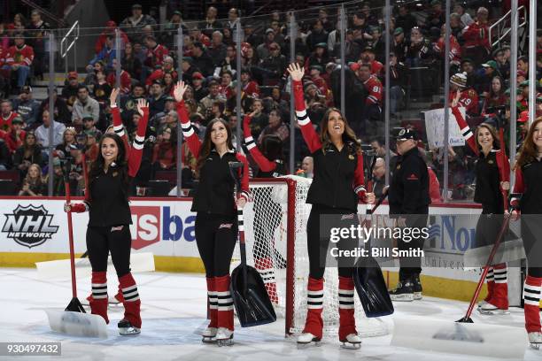 The Chicago Blackhawks ice-crew waves to the crowd during the game between the Chicago Blackhawks and the Boston Bruins at the United Center on March...