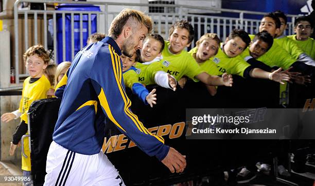 David Beckham of the Los Angeles Galaxy high fives children as he heads to the locker room prior to the start of the MLS Western Conference...