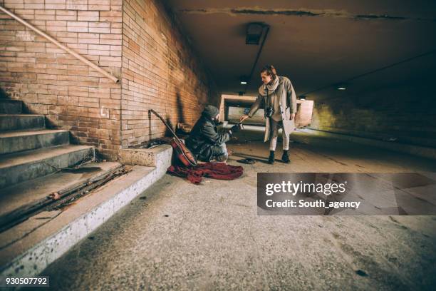 geven van geld aan dakloze vrouw - aalmoes stockfoto's en -beelden