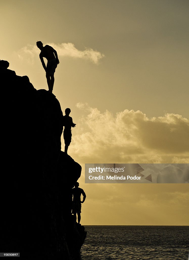 Three young man standing on a rock