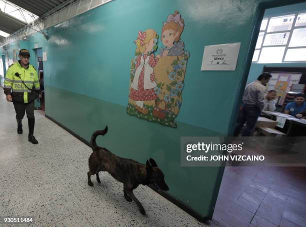 Policeman and his dog patrol a polling station in Bogota during parliamentary elections in Colombia on March 11, 2018. Colombians went to the polls...