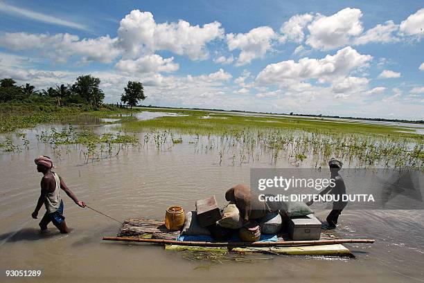 Nepalese flood-affected villagers wades through flood waters as they carry their belongings at a flood-affected area in Lockey village in Sunsari...