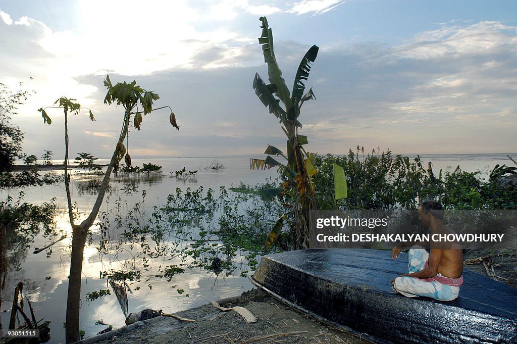 An Indian villager sits on his boat look