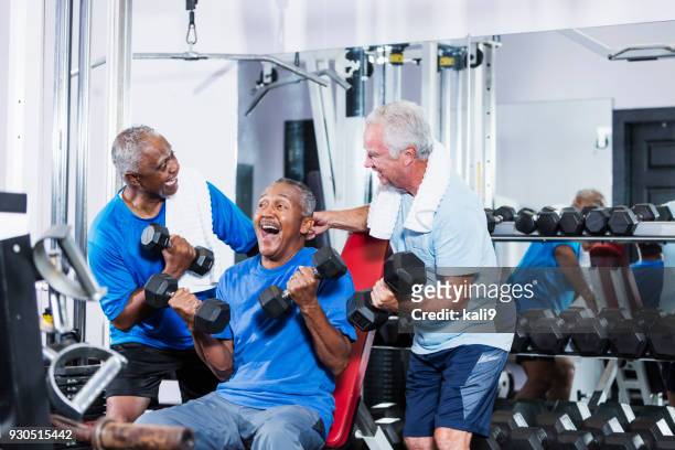 three senior multi-ethnic men working out at gym talking - after workout towel happy stock pictures, royalty-free photos & images
