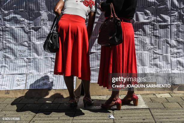 Women check the electoral roll at a polling station in Medellin, Antioquia Department, during parliamentary elections in Colombia on March 11, 2018....