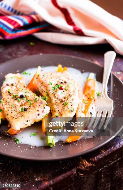 roasted white fish fillet with cream sauce and baby carrots on a plate, selective focus - peppercorn sauce stock pictures, royalty-free photos & images